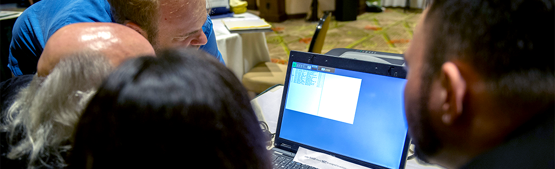 Students and coaches working on computer at tournament